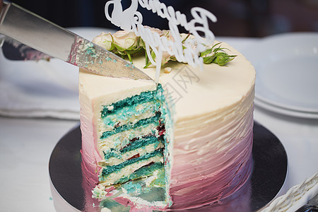 新娘和新郎蓝色的美丽的婚礼蛋糕和鲜花的小蓝切片背景