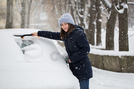 一个女人从车挡风玻璃上取下雪天气雪堆安全汽车风暴划痕成人驾驶工作暴风雪图片