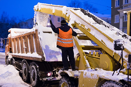 爪式装载机车辆清除道路上的积雪 除雪机和除雪车清理城市的积雪街道图片