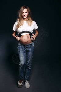 肚子上有大耳机的孕妇微笑着情感工作室女士母性希望压痛女性孩子母亲幸福图片