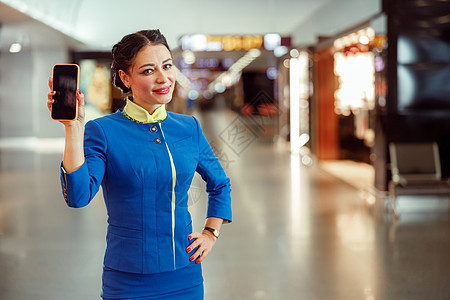 机场终端站着的带手机的快乐空姐们飞机服务员女士航空公司航班工人国际电话航空工具图片