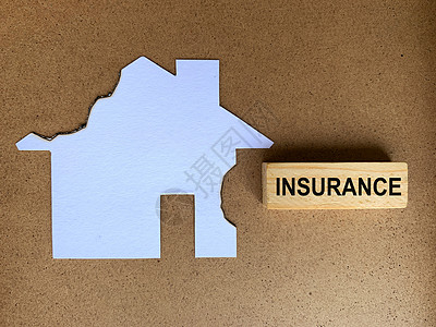 带有烧焦的模范房屋背景的木制木板上的保险文本 保险概念图片