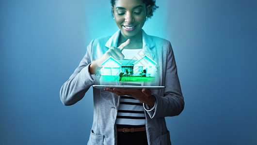工作室拍摄了一位年轻女商务人士使用数字平板电脑的镜头 上面有蓝色背景的地貌图象图片