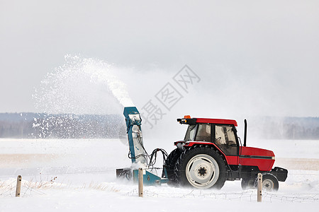 在农村布局中 红拖风雪吹着一条车道机器风暴打扫雪堆工作季节降雪耕作投掷者服务图片