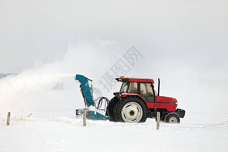 在农村布局中 红拖风雪吹着一条车道服务投掷者打扫耕作雪堆车辆机械季节工作暴风雪图片