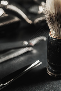 在黑色的表面上是旧的理发工具 剃须刷老式手动理发器 梳子 剃刀 美发剪刀 黑色单色 特写 理发店背景 对比阴影发型工具修剪学校皮图片