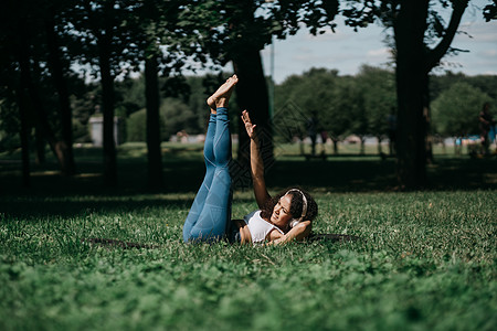 运动的年轻女子在市公园里做锻炼图片