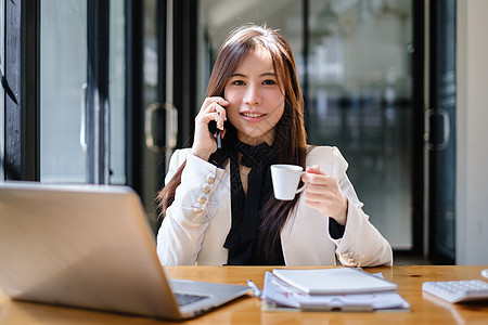 亚洲女商务人士与业务团队通过手机通话分析技术价格图表和指标 帐户或存钱或保险概念金子计算订金会计文档抵押经济债务投资预算图片