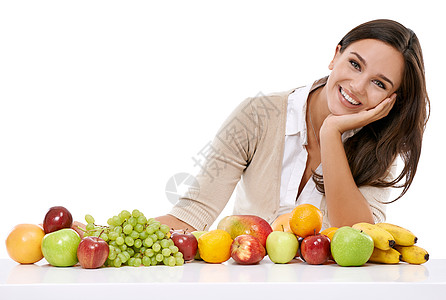 一位微笑的年轻女子坐在水果边上 享受大自然的恩赐图片