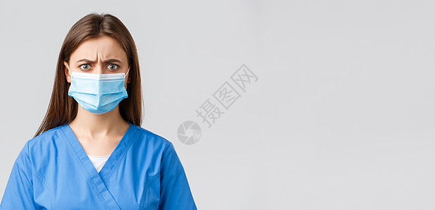 Covid19 预防病毒 健康 医护人员和检疫概念 愤怒或沮丧的女护士对坏消息做出反应 穿蓝色磨砂膏和医用口罩的医生失望地皱着眉图片