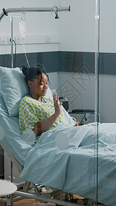 年轻妇女在智能手机视频电话上挥手情况朋友们速度诊所监视器医院互联网房间技术成人图片