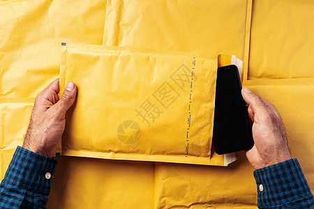 男性用双手包装运输的泡沫信封图片