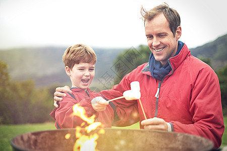 我等不及要吃它们了 父亲和儿子在火上烤棉花糖图片
