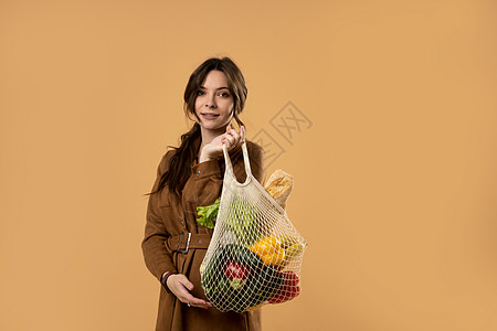 美丽迷人的快乐黑发女人拿着装有蔬菜的网状杂货袋 没有塑料的概念 零浪费 无塑料 生态友好的概念 可持续的生活方式棉布女性空间杂货图片