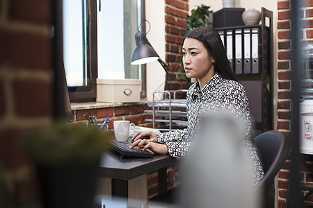 自信的办公室女职工在使用工作计算机和坐在办公桌旁的同时 重新推出总体项目营销理念图片