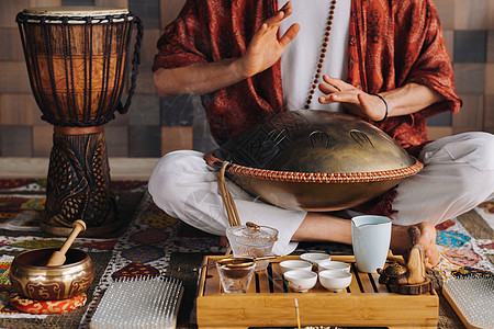 在茶叶仪式期间 用猎户座舌鼓敲响一个演奏现代乐器的人的手贴近艺术品音乐家冥想谐振活力文化雕塑振动游戏治疗图片