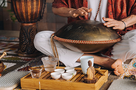 在茶叶仪式期间 用猎户座舌鼓敲响一个演奏现代乐器的人的手贴近游戏艺术品活力音乐家民谣振动雕塑文化治疗谐振图片