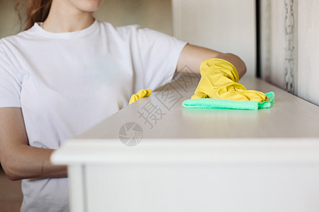 穿黄色防护橡胶手套 擦洗家具的女孩被割除图片