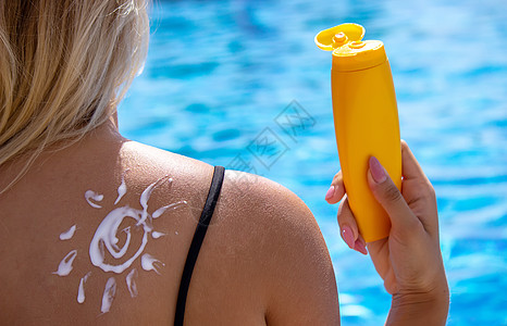 女孩背上画着太阳的图画 在泳池旁边放松一下比基尼身体护理晴天海洋假期肩膀女性洗剂微笑图片