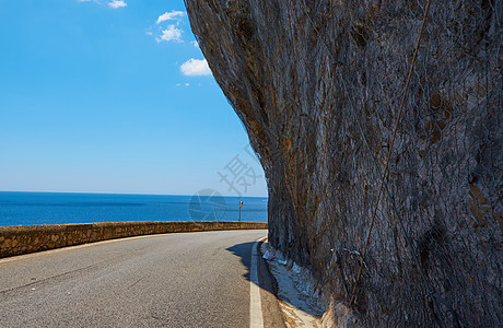 柏油路 五颜六色的风景与美丽的山路与完美的沥青 高高的岩石 夏天日出时的蓝天 复古色调 旅行背景 在山的高速公路缠绕速度路线阳光图片