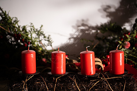红蜡烛是圣诞节壁炉的装饰品 图亚树和其他树木的绿色树枝以装饰方式安排庆典阴影云杉辉光风格传统房间客厅灯芯工艺背景图片