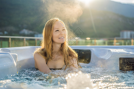 在绿色大山的背景下享受快乐旅行时刻假期生活的年轻无忧无虑的快乐微笑女人在热水浴缸中放松的肖像自由酒店液体游客温泉身体管子全景漩涡图片