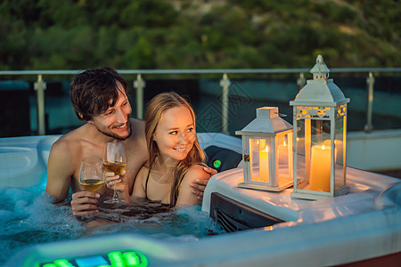 在绿色大山的背景下 享受快乐旅行时光假期生活的年轻无忧无虑的快乐微笑夫妇在热水浴缸中放松的肖像压力惊喜男人周年女孩护理蜜月身体治图片