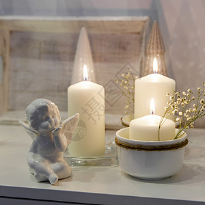 装饰圣诞节房子的概念 点燃蜡烛 园林 迪斯科舞团 白箱柜子上的天使雕像 文字放在何处小样花瓶框架柳条托盘烛台陶瓷植物公寓艺术品背景