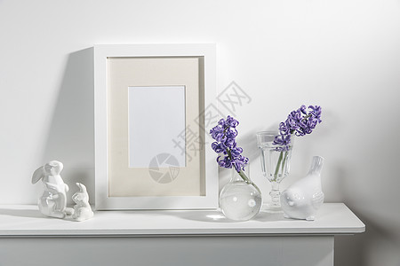 大瓷碗里的白色风信子 书籍 野兔和鸟的雕像 一个空的相框放在壁炉上 靠着白色的墙壁 布局兔子装饰玻璃沙发塑像房间植物制品白墙陶瓷背景图片
