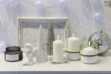 装饰圣诞节房子的概念 点燃蜡烛 园林 迪斯科舞团 白箱柜子上的天使雕像 文字放在何处公寓植物塑像阴影烛台柳条帆布小样花瓶制品背景图片