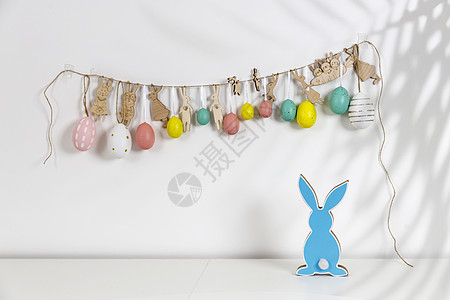 内部的片段 为复活节装饰的儿童房 墙上挂着一个用硬纸板剪成的塑料鸡蛋和兔子组成的花环 木蓝兔 您的文本的地方 复活节贺卡图片