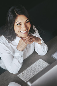 生意蒸蒸日上 一位在电脑上工作的年轻女商务人士的高角度肖像图片