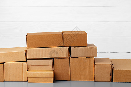 一组纸板箱 以白色木壁为挡板店铺船运送货邮件木头办公室纸板礼物团体邮政图片