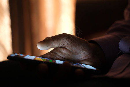 晚上用智能手机亲近年轻男子的手短信触摸屏机动性工具展示犯罪消息电话屏幕手指图片