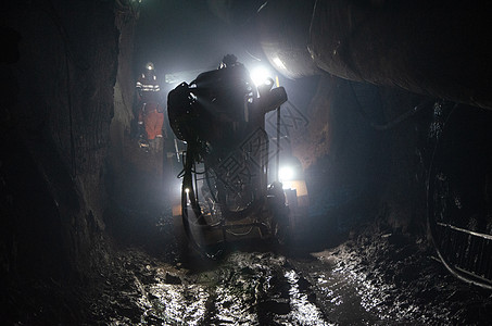 采矿经营者的采矿机 地下矿网目矿物质工人运营商机械灰尘软管安全工作男人地面图片