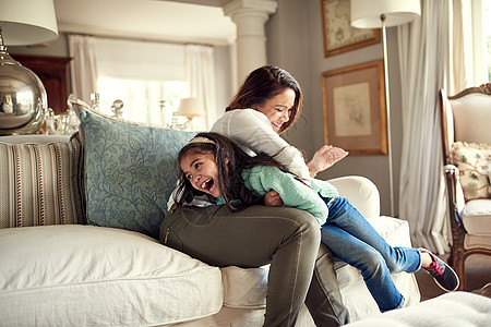 母女俩的时刻充满了乐趣 拍摄的一对母女在家里的沙发上玩得很开心图片
