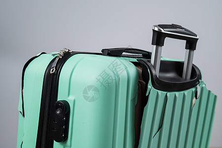 重疾保险在一个白色背景的破碎塑料手提箱缝合失败保险塑料蓝色运输航程航空公司贮存旅行航班背景