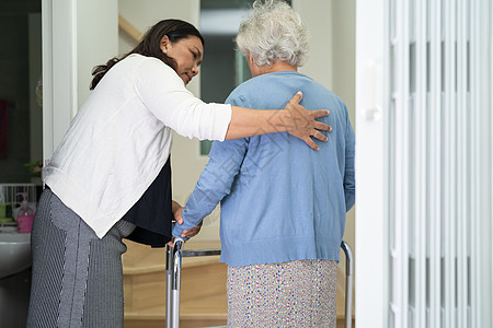 护理员帮助年老或年老的老年妇女在家中楼梯上行走时配有助行器日常生活护士平衡房子护理服务助手医院损失女士图片