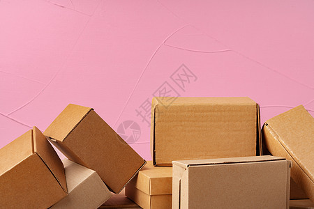 粉红色背景的一套纸板盒商业邮件小样船运牛皮纸粉色空白邮递员礼物团体图片