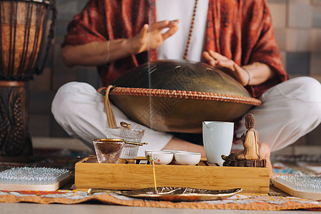 在茶叶仪式期间 用猎户座舌鼓敲响一个演奏现代乐器的人的手贴近音乐家音乐文化装饰品游戏韵律旋律治疗冥想语言图片
