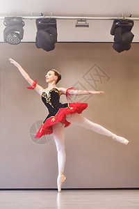一位年轻的芭蕾舞演员优雅地站在演播室里 脚趾上穿着足尖鞋 芭蕾舞学生在表演前在演播室练习古典舞魅力优美短裙女性灵活性平衡工作室舞图片