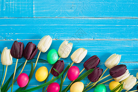 复活节鸡蛋和蓝木木木板上的郁金香木头蓝色礼物假期篮子庆典橙子食物团体季节图片