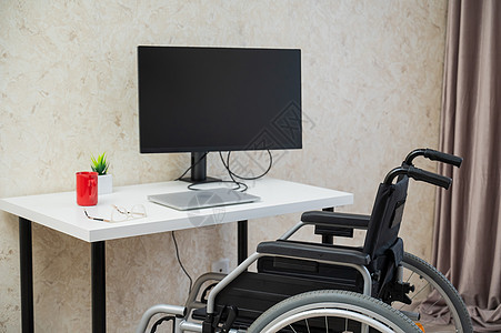 残疾人工作场所 带电脑的轮椅在桌子上 请携带电脑的轮椅背景图片