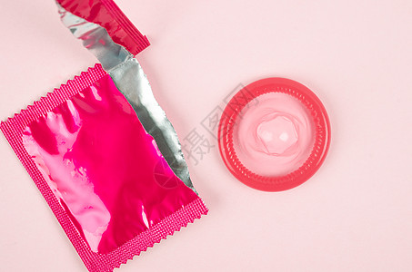 粉红色在粉红背景上打开了避孕套和保险套摄影主题控制避孕人造物医疗情感润滑乳胶商品图片