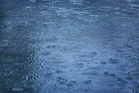 游泳池的雨滴落水坑池塘运动风暴涟漪飞溅水滴反射波纹环境图片