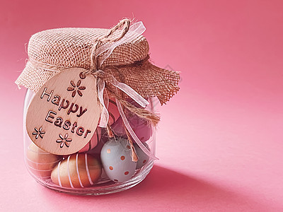 复活节快乐 在粉红背景 基督教宗教和假日的玻璃罐中以玻璃罐装着多彩涂彩的东面彩蛋图片