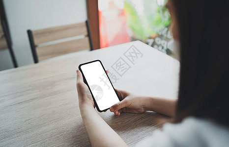 亚洲女人拿着手机短信或信息 女商务人士使用现代智能手机浏览网页 阅读电子书 交易股票图片
