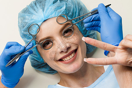 在白色背景上咨询整形外科医生 美容振兴面部护理 戴蓝色医用手套的医生摸女孩脸注射器治疗注射嘴唇病人塑料化妆品药品程序皮肤图片