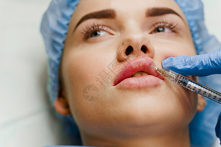 整形外科医生确实在诊所的嘴唇上注射过针 进行化妆性美容面部复健治疗 对有吸引力的女孩进行口腔增生注射皮肤轮廓塑料皱纹病人程序手套图片