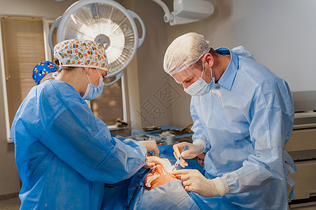 脂肪填充手术 2 名外科医生在医疗诊所进行名为眼睑成形术的整形手术 外科医生用手术刀做一个切口药品成人考试医院皮肤工作化妆品保健图片